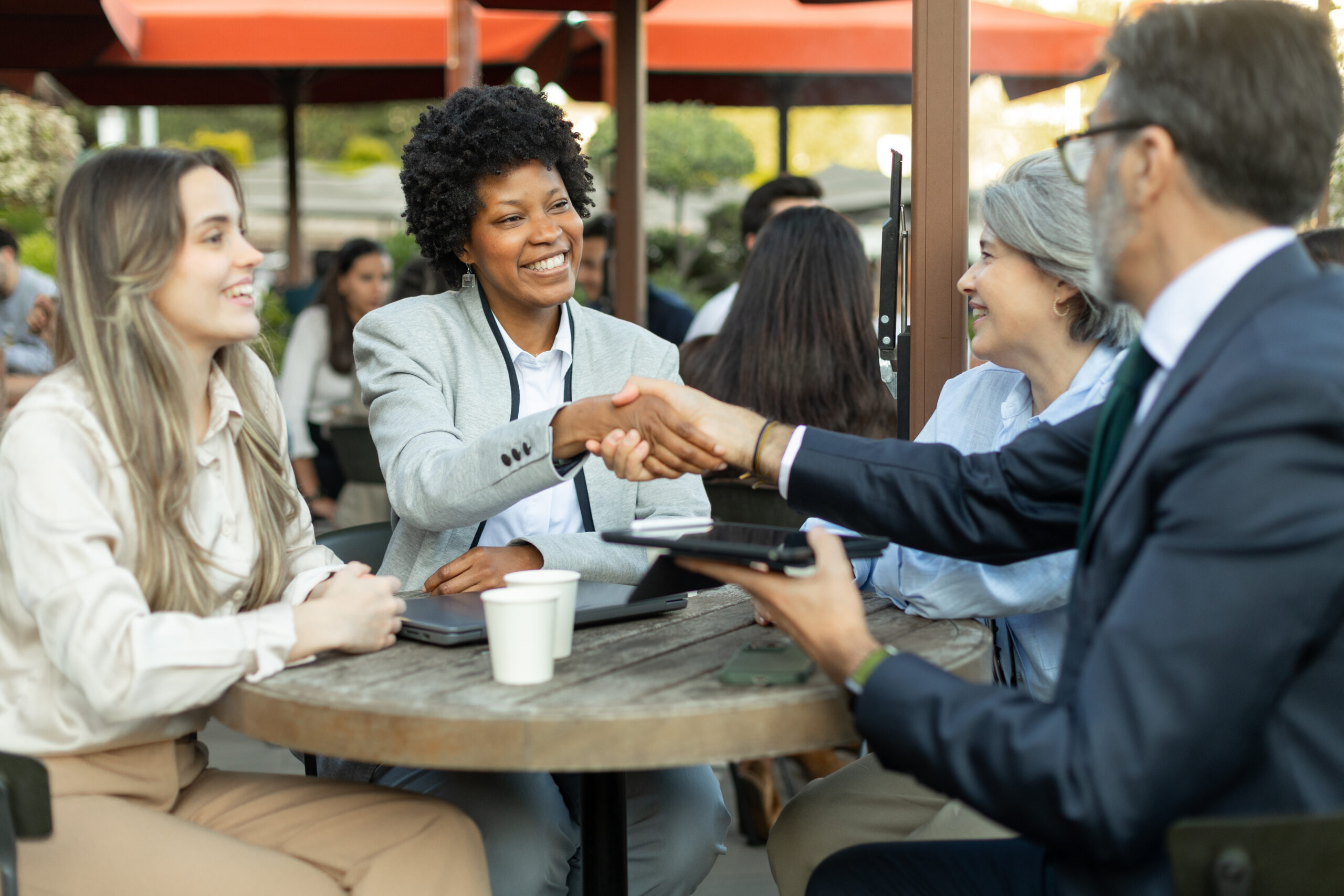 Professionals shake hands during a friendly meeting, showing face-to-face marketing in action.