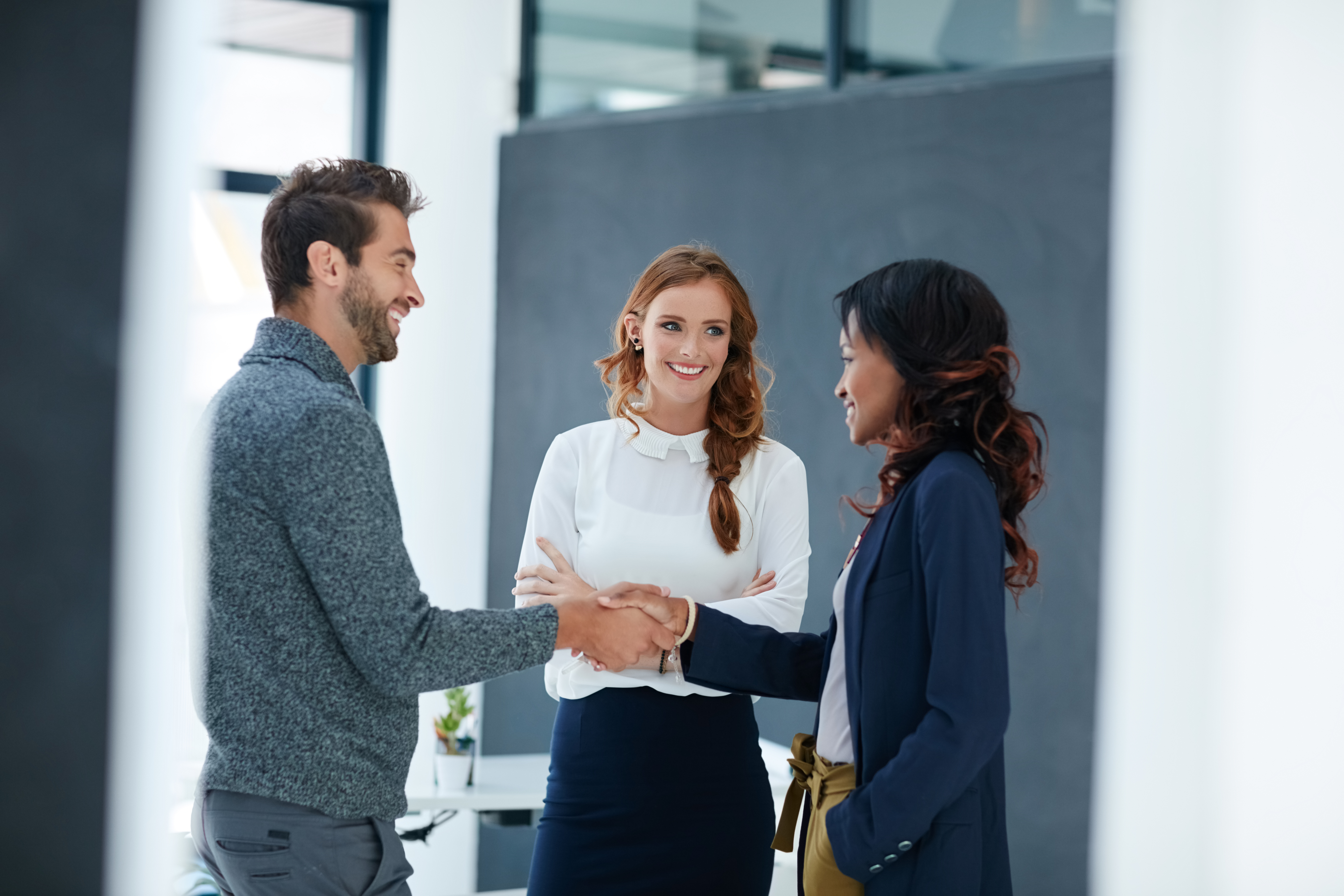 Professionals shaking hands in a meeting, building a strong client relationship through trust and collaboration.
